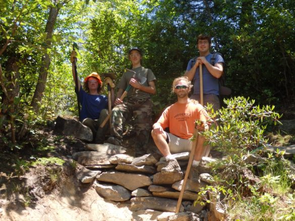 Volunteers show off stone cribbing on the Babel Tower trail